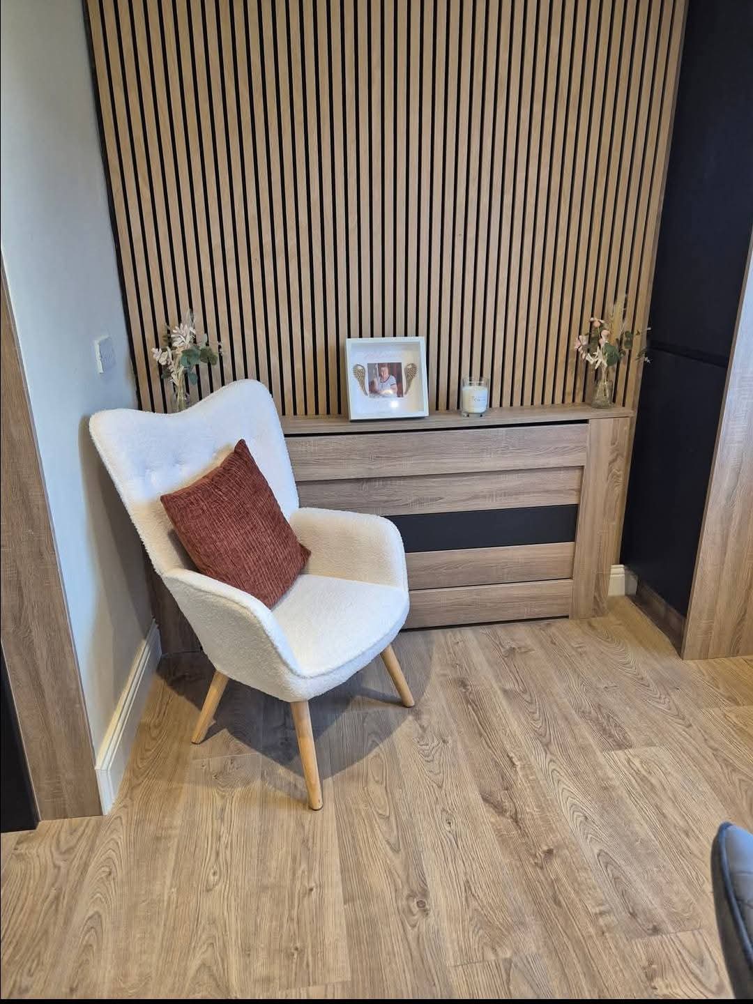 Oak slat feature wall with matching timber radiator cover in a living space