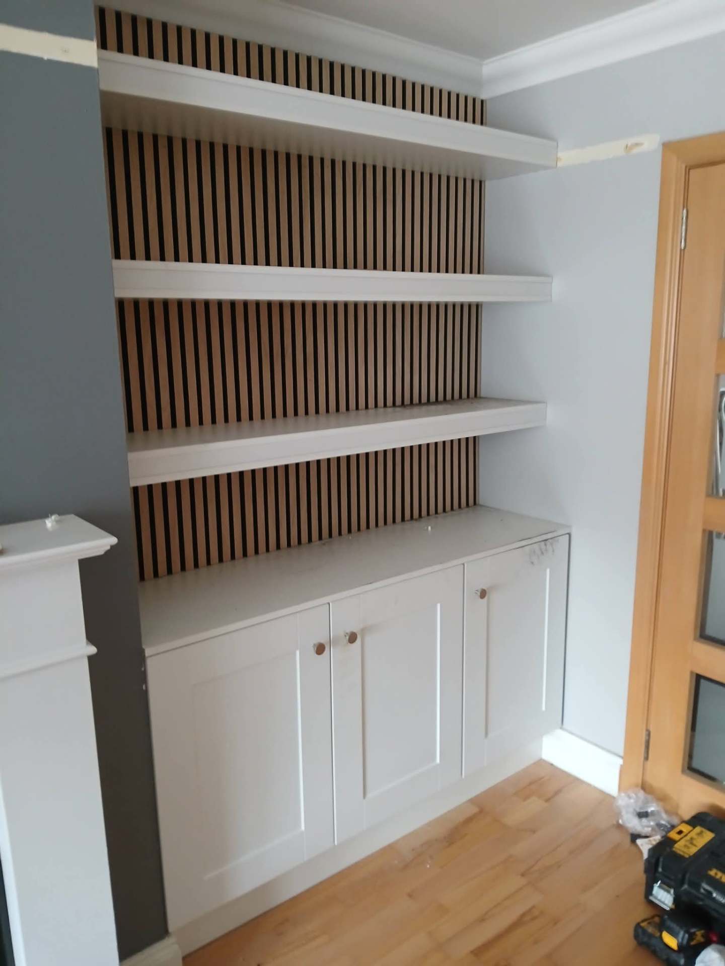 Alcove unit with painted floating shelves, oak slat panel backdrop and shaker base cupboards