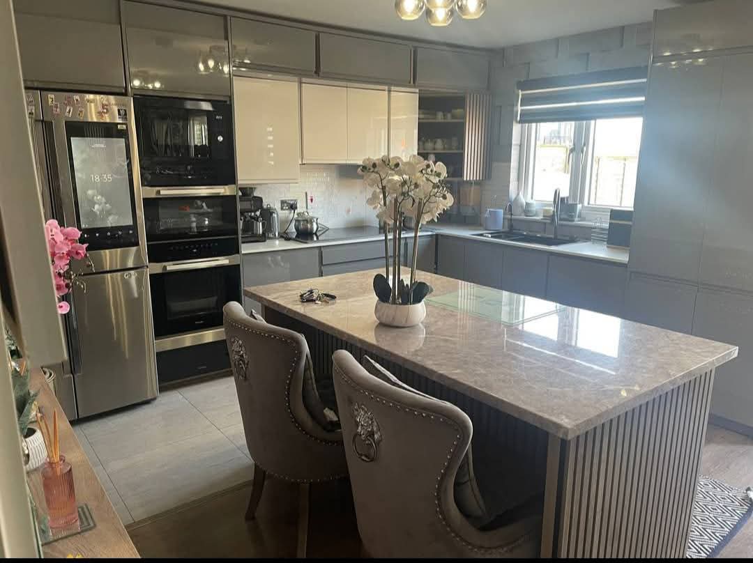 Bright grey gloss fitted kitchen with marble island and integrated appliances